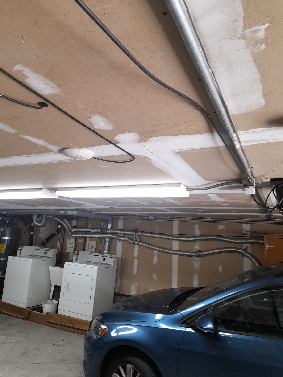 Ceiling-mounted access point in a garage with cable run along the joists