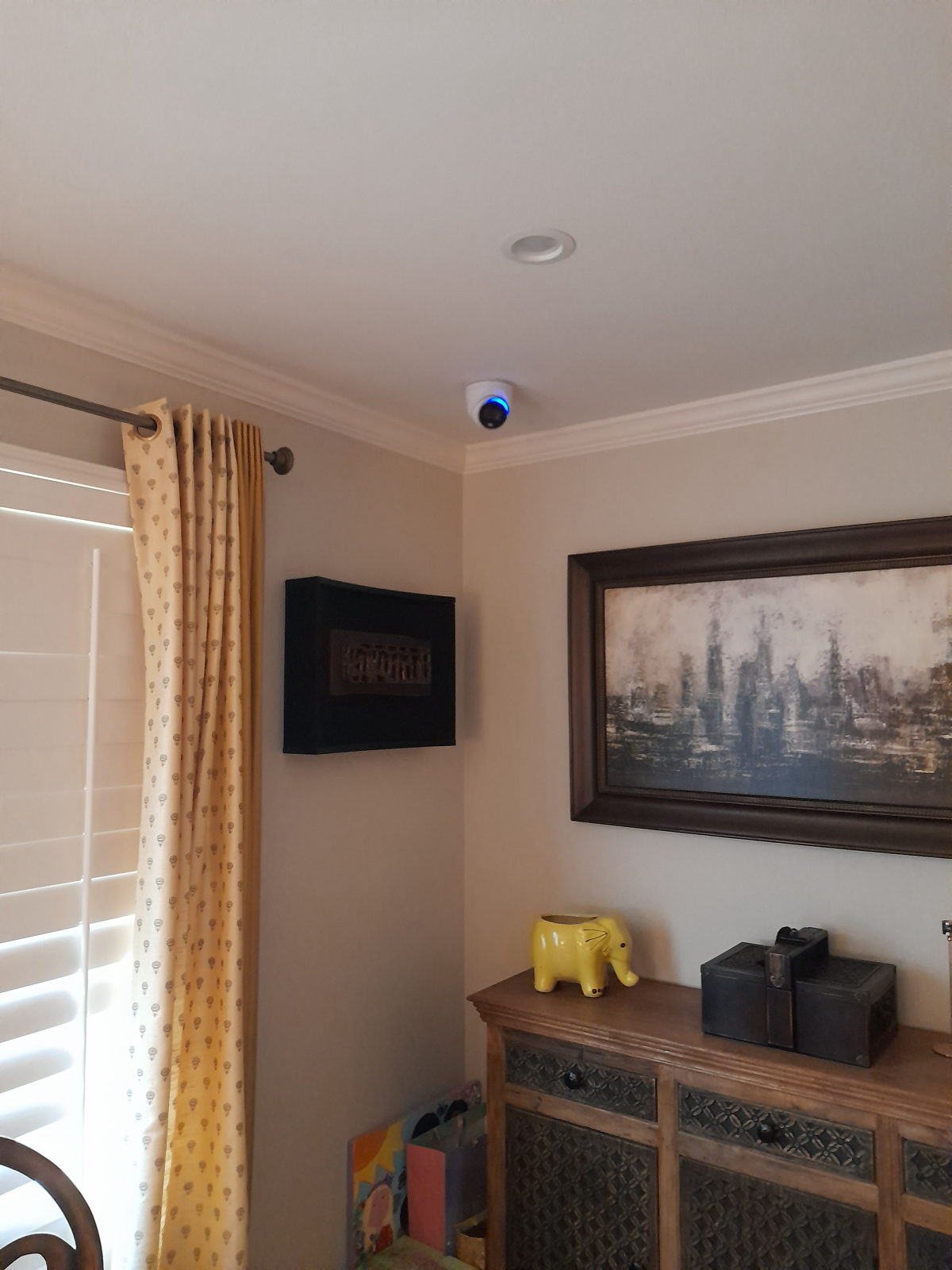 Indoor dome camera mounted flush to a ceiling in a corner of a room