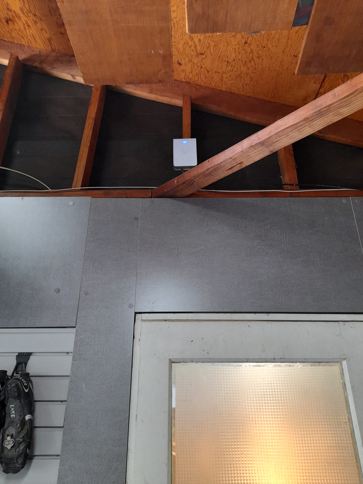 Wall-mounted Wi-Fi access point on garage rafters above a door