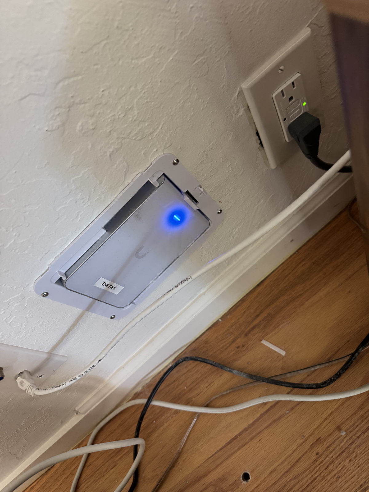 UniFi access point mounted in a recessed wall box with Cat6 cable, labeled DATA1.