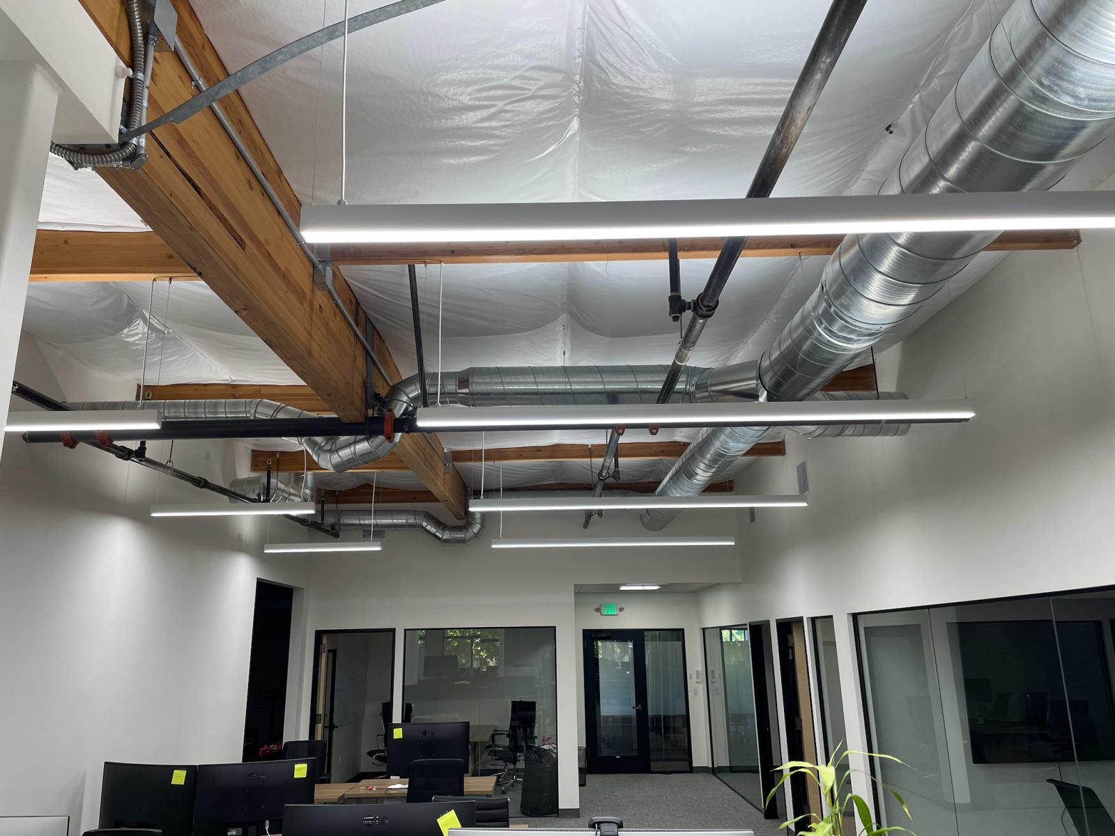 Open office ceiling with exposed ductwork and wood beams