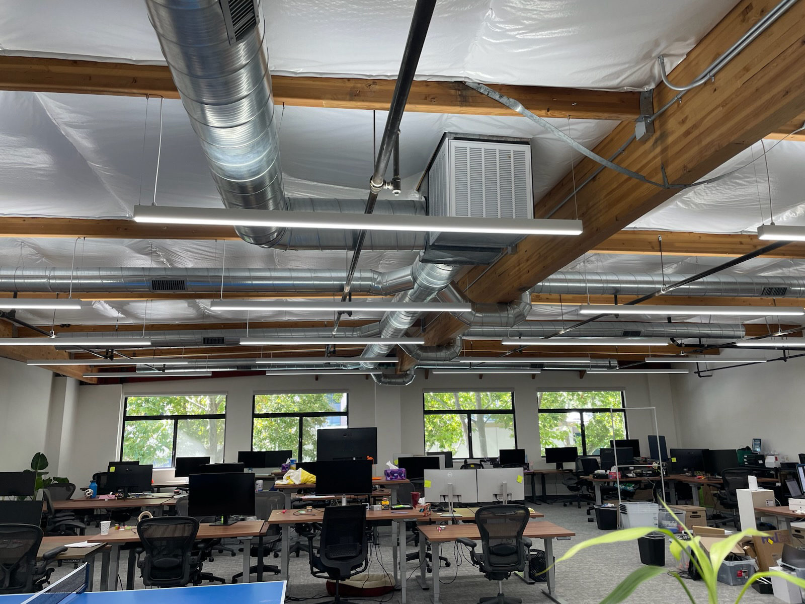 Open office workspace with desks and exposed ceiling